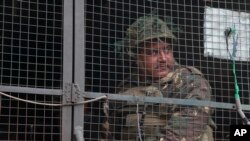 FILE - An Indian army soldier looks from inside an army vehicle at the Indian air force base in Pathankot, India, Jan. 4, 2016.