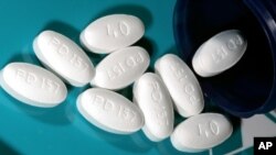 FILE - This Nov. 15, 2005 file photo shows 40 milligram tablets of Lipitor, one kind of statin used for lowering blood cholesterol, in Glen Rock, New Jersey.