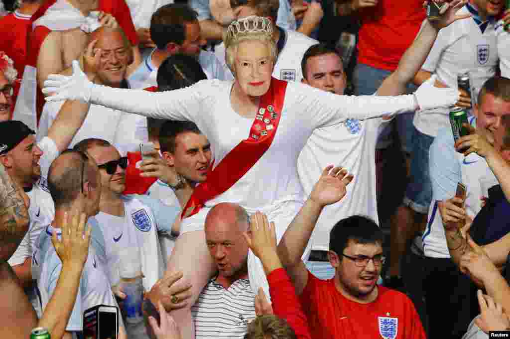 An English fan wears a mask of Queen Elizabeth II in Saint Etienne, France, before the Euro 2016 football match between England and Slovakia.