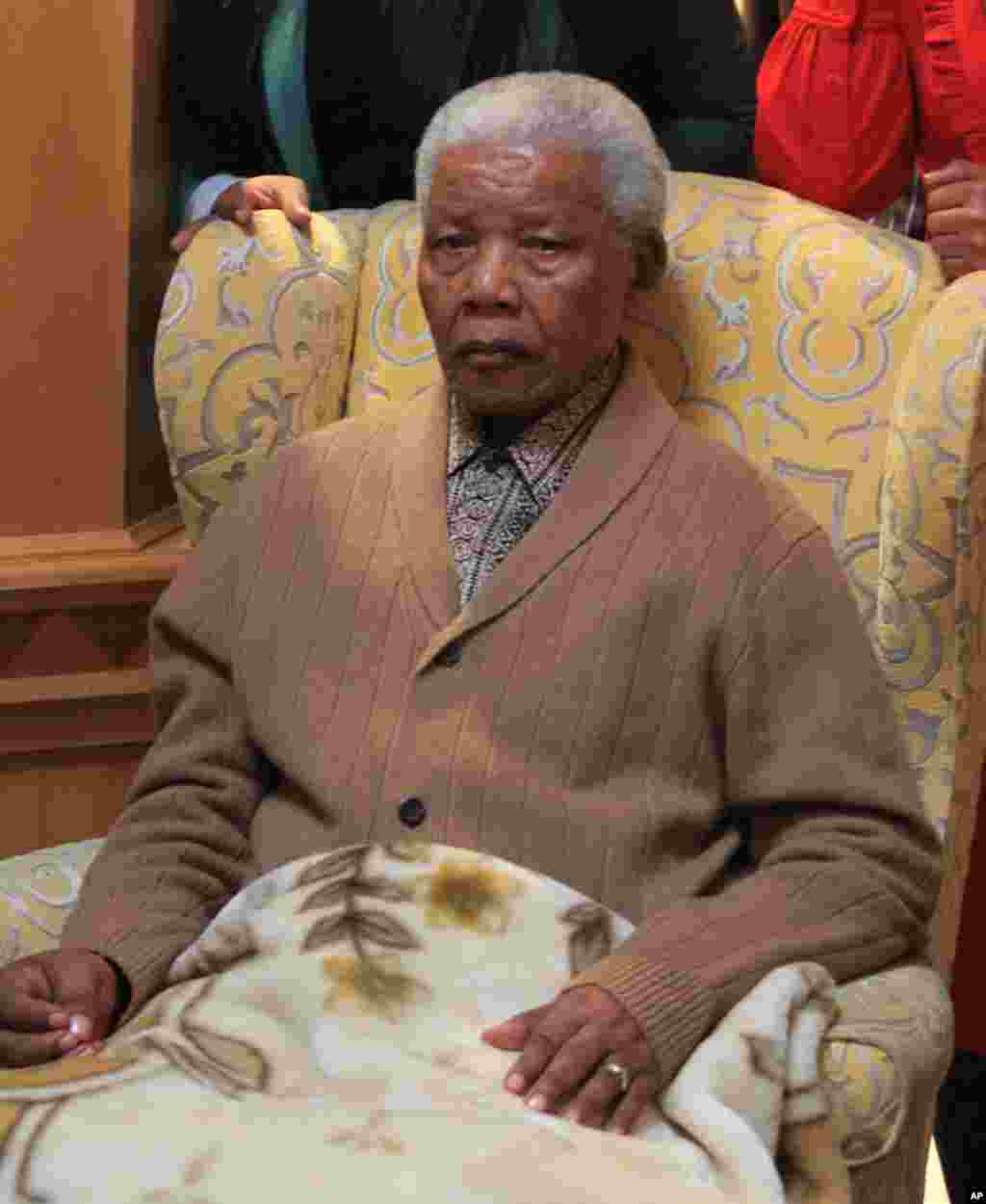 Nelson Mandela poses for a photograph after receiving a torch to celebrate the African National Congress' centenary in his home village Qunu, May 30, 2012.