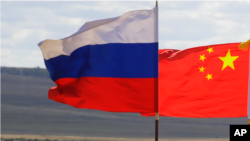 Bendera Rusia dan China terlihat sedang berkibar. (Foto: AP)