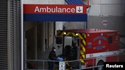 Petugas medis menurunkan pasien dari dalam ambulans di Rumah Sakit Houston Methodist di Texas Medical Center saat pandemi Covid-19 merebak di Houston, Texas, 8 Juli 2020. (Foto: dok). AS mencatat 150 ribu kasus baru Covid-19 di berbagai penjuru AS, 21 November 2020. 