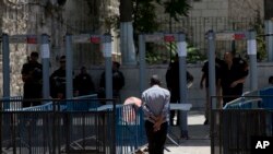 Seorang pria Palestina berjalan menuju sebuah detektor logam di kompleks Masjid Al Aqsa di Kota Tua Yerusalem, 19 Juli 2017. Sebuah perselisihan mengenai detektor logam telah meningkat menjadi pertikaian baru antara Israel dan dunia Muslim.