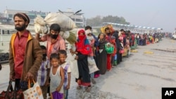 FILE - Rohingya refugees headed to the Bhasan Char island prepare to board navy vessels from the south eastern port city of Chattogram, Bangladesh. 