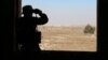 A rebel fighter looks through binoculars in Quneitra countryside, Syria, Sept. 10, 2016.