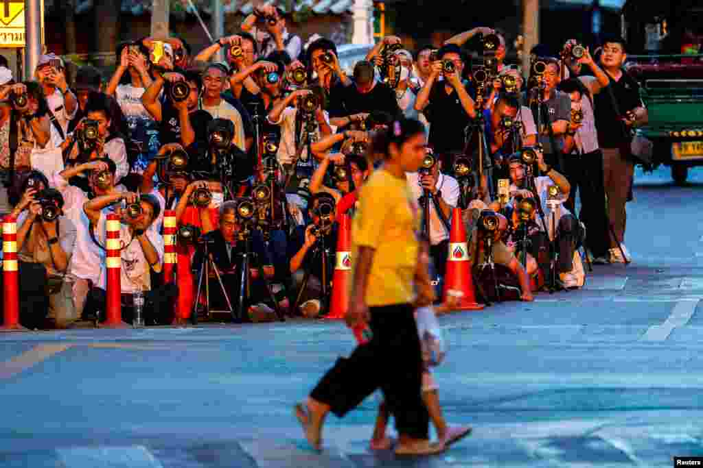 Orang-orang menyeberang jalan, saat fotografer mengambil gambar matahari terbenam di balik Ayunan Raksasa, juga dikenal sebagai Sao Chingcha, di Bangkok, Thailand. (Reuters) 