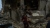 A woman walks through a housing complex destroyed in recent battles, in Nagorno Karabakh, Oct. 10, 2020. (Yan Boechat/VOA) 