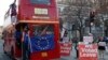 Anti-Brexit protesters on board a hired red London bus demonstrate as they drive past the Houses of Parliament in London, Jan. 28, 2019. 
