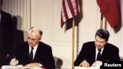 Le président Ronald Reagan et le président soviétique Mikhaïl Gorbatchev signent le Traité sur les armes nucléaires de portée intermédiaire, Maison-Blanche, le 8 décembre 1987.