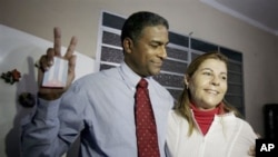 Cuba's dissident Oscar Elias Biscet makes the victory sign as he embraces his wife Elsa Morejon after being released from jail in Havana, Cuba, March 11, 2011