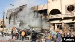 Petugas bekerja memadamkan kebakaran di lokasi serangan bom mobil di Kirkuk (23/8). (Reuters/Ako Rasheed)