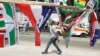 A man walk past election campaign flags on a street in Accra, Ghana, Dec. 6, 2016. Polls will open Dec. 7 at 0700 UTC.