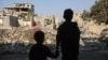 Anak-anak memandang ke arah bangunan yang hancur akibat serangan udara Israel di kamp pengungsi Nuseirat di pusat Jalur Gaza, Kamis, 7 November 2024. (Foto: Eyad Baba/AFP)