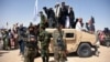 Para militan Taliban Afghanistan dan warga berdiri di kendaraan lapis baja milik Tentara Nasional Afghanistan merayakan gencatan senjata pada hari ketiga Idul Fitri, di Distrik Maiwand, Provinsi Kandahar, 17 Juni 2018. (Foto: Javed Tanveer/AFP)