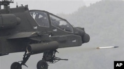 FILE - A US Apache helicopter fires a rocket.