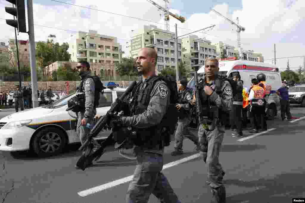 Israeli police officers approach the scene of an attack in Jerusalem, Nov. 5, 2014.