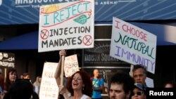 An anti-vaccine protester holds a banner outside Madison Square Garden ahead of a Foo Fighters' show, which required proof of vaccination to enter, in New York City, U.S., June 20, 2021. 