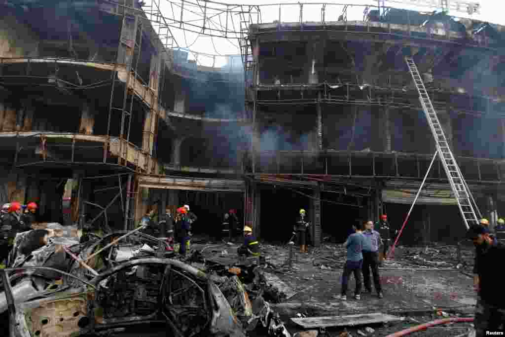 People gather at the site of a suicide car bomb in the Karrada shopping area in Baghdad, July 3, 2016.