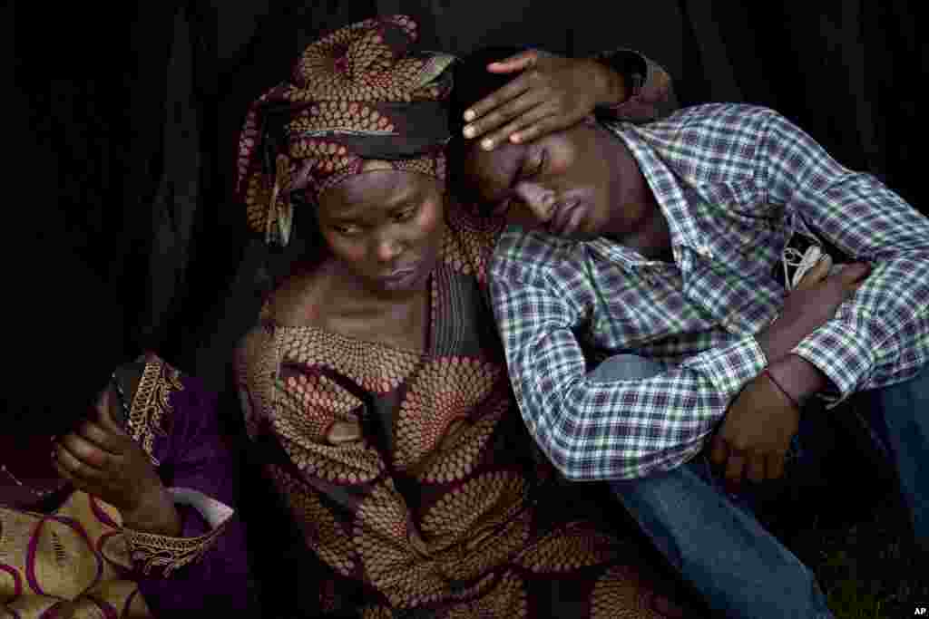 Bizimana Emmanuel, who was born two years before the genocide, is consoled by an unidentified woman while attending a ceremony to mark the 20th anniversary of the Rwandan genocide, at Amahoro stadium in Kigali, April 7, 2014.
