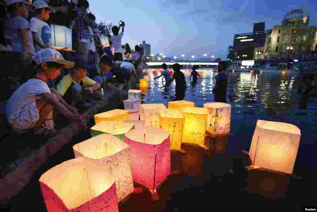 People release paper lanterns on the Motoyasu river facing the gutted Atomic Bomb Dome in remembrance of atomic bomb victims in Hiroshima, August 6, 2013. (Kyodo)
