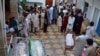 FILE - Pakistani Shi'ite Muslims gather around bodies of the victims of a suicide bombing for which the Sunni militant group Lashkar-e-Jhangvi claimed responsibility in Quetta, Pakistan, July 1, 2013.