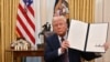Donald Trump brandit un décret dans le bureau ovale de la Maison Blanche à Washington, DC, le 23 janvier 2025.