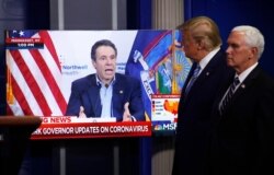 Vice President Mike Pence, right, and President Donald Trump watch a video of New York Gov. Andrew Cuomo speaking during a coronavirus task force briefing at the White House, Sunday, April 19, 2020, in Washington.