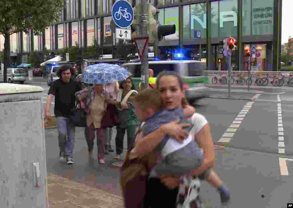 Members of the public run away from the Olympia Einkaufszentrum mall, after a shooting, in Munich, Germany, July 22, 2016.