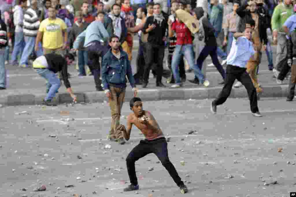 Protesters hurl stones during clashes between supporters and opponents of President Mohamed Morsi in Alexandria, Egypt, November 23, 2012. 