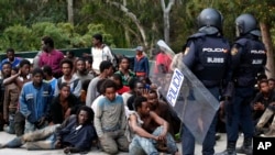 Des policiers surveillent des migrants venant d'arriver à Ceuta, le 17 février 2017.