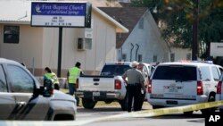 FILE - Law enforcement officers gather in front of the First Baptist Church of Sutherland Springs, Texas, after a fatal shooting, Nov. 5, 2017.