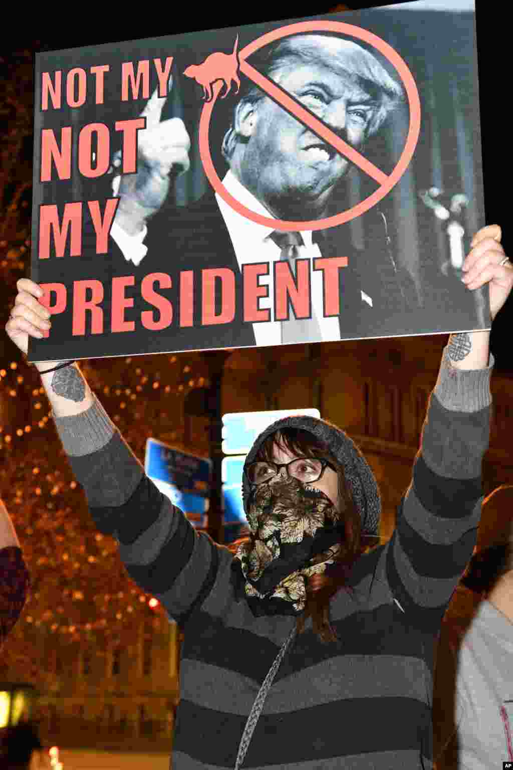 Seorang demonstran memegang papan bertuliskan &quot;Bukan Presiden Saya&quot; sebagai protes atas terpilihnya Donald Trump sebagai presiden AS, di Jefferson Square Park di Louisville, Kentucky (10/11). (AP/Timothy D. Easley)