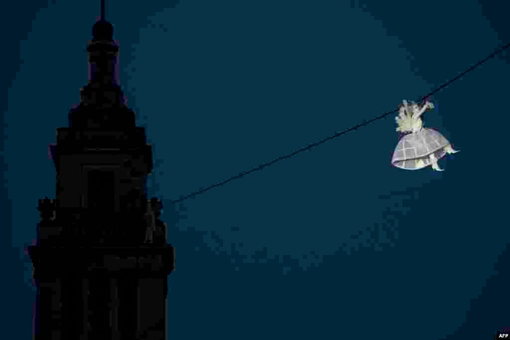 A performer is suspended from high-wires during the outdoor aerial performance of the show "Place des Anges" (Angels' square), performed by French theater producers Gratte Ciel, in Kingston up Hull, north east England, July 2, 2016.
