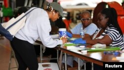 Seorang pemilih menandatangani pendaftaran sebelum memasukkan suara pada pemilihan pendahuluan partai Demokrat di Miami, Florida, 17 Maret 2020.
