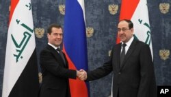 Russian Prime Minister Dmitry Medvedev shake hands with Iraq's Prime Minister Nouri Al-Maliki, right, prior to their meeting in the Gorki residence outside Moscow, October 9, 2012.