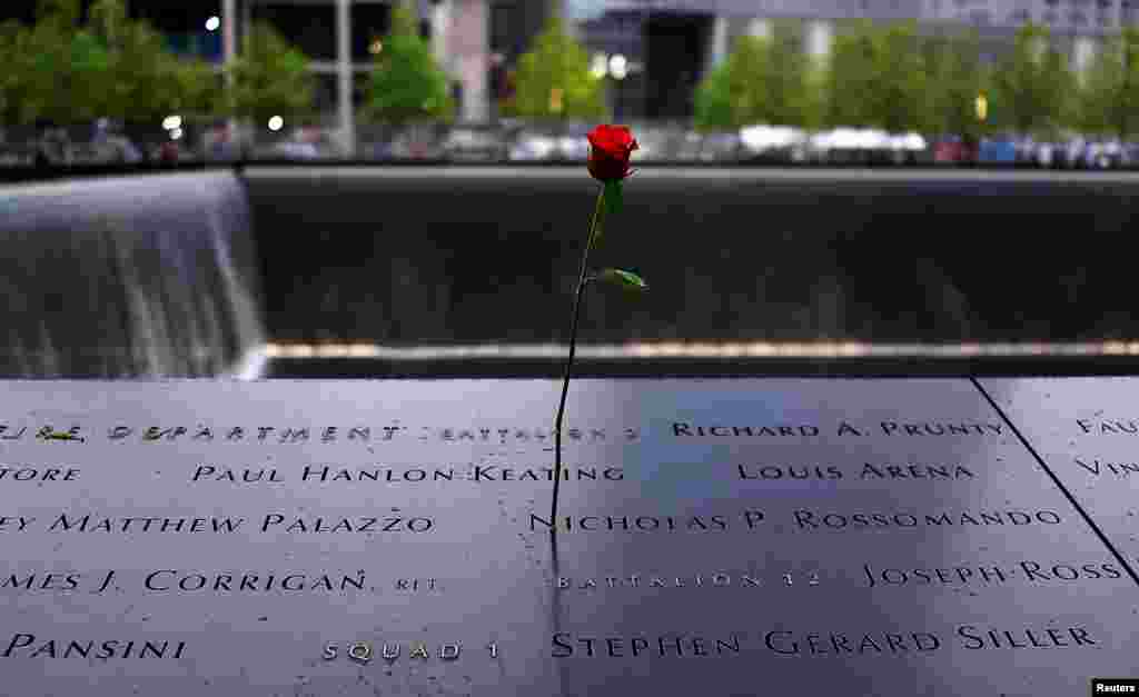 Wardi likiwekwa katika nakshi ya jina lililoandikwa katika eneo la South reflecting pool kwenye eneo la kumbukumbu - Ground Zero - katika hafla iliyotengwa rasmi kwa ajili ya Makumbusho ya Kumbukumbu ya Kitaifa ya Septemba 11 New York, Mei 15, 2014.