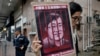 FILE - A protester holds a picture of Chinese human rights lawyer Wang Quanzhang during a protest outside the Chinese liaison office in Hong Kong, July 13, 2018.