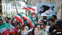 Para pengunjuk rasa mengusung poster-poster dalam unjuk rasa di New York untuk menyampaikan solidaritas kepada perempuan Iran pada peringatan satu tahun meninggalnya perempuan Kurdi-Iran, Mahsa Amini, dalam tahanan, Sabtu, 16 September 2023. (Foto: Kena Betancur/AFP)