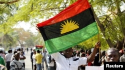 FILE - A supporter of Indigenous People of Biafra (IPOB) leader Nnamdi Kanu holds a Biafra flag during a rally in support of Kanu in Abuja, Nigeria, Dec. 1, 2015.