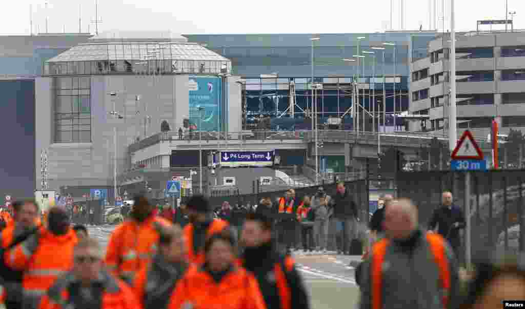 Warga meninggalkan lokasi ledakan di bandar udara Zaventem dekat Brussels, Belgia (22/3). (Reuters/Francois Lenoir)