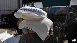 Palestinians receive food aid at a U.N. warehouse in the Shati refugee camp, Gaza City, Jan. 14, 2018.