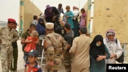 Sojojin Iraqi suna taimakawa mutanen dake arcewa daga Fallujah, Iraqi.