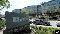 FILE - A YouTube sign is shown across the street from the company's offices in San Bruno, California, April 3, 2018.
