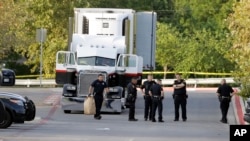 Polisi San Antonio police menyelidiki lokasi penyelundupan imigran pada hari Mingug, 23 Juli 2017, di mana delapan orang teewas di traktor-trailer.