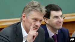 Russian President Vladimir Putin's spokesman Dmitry Peskov, left, speaks during a meeting in Moscow, Russia, Dec. 9, 2012.