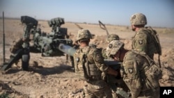 FILE - U.S. soldiers ready a howitzer to be towed into position at Bost Airfield in Afghanistan's Helmand Province in this June 10, 2017 photo provided by Operation Resolute Support. The U.S. and NATO deny Iranian allegations that U.S. troops in Afghanistan support Islamic State militants.