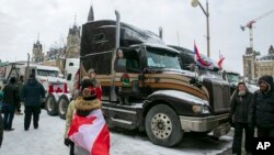 Stephanie Ravensbergen, 31 an, monte nan kamyon fanmi li nan Ottawa, Ontario, Samdi 12 Fevriye 2022. Li vin nan zon nan pou apiye matant li ak mononk li kap pwoteste kont egzijans vaksinasyon COVID-19 gouvenman Kanadyen an . 