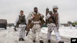 Wanajeshi wa Ukraine wakitembea kwa mgu wakati wa mazoezi ya kijeshi karibu na mji wa Ukraine wa Kharkiv. Februari 10, 2022. Picha ya AP