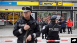 Police officers secure the area after a knife attack at a supermarket in Hamburg, Germany, July 28, 2017.