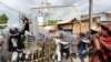 Para migran melemparkan pagar ke arah anggota Garda Nasional dalam aksi protes di luar kantor National Migration Institute (INM) di Tapachula, Meksiko 22 Februari 2022. (REUTERS/Jacob Garcia)